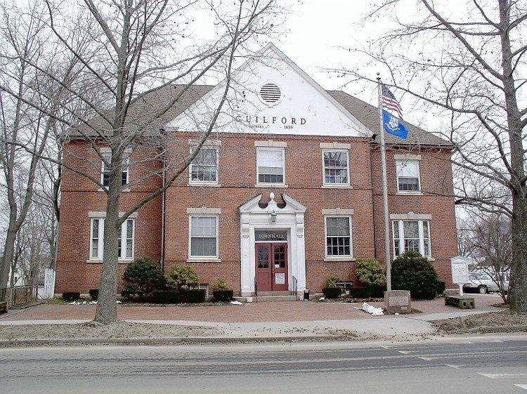 Guilford Town Hall, a red brick municipal building with American flag