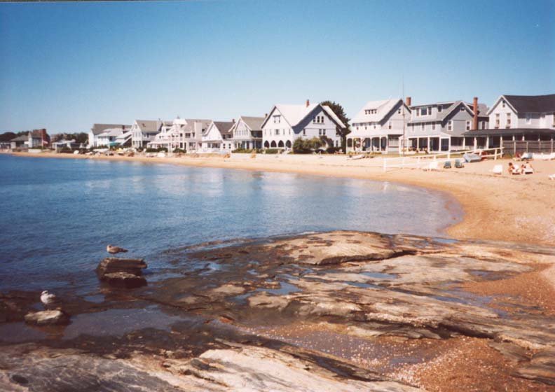 Beachfront homes along the rocky Madison, CT shoreline with calm waters