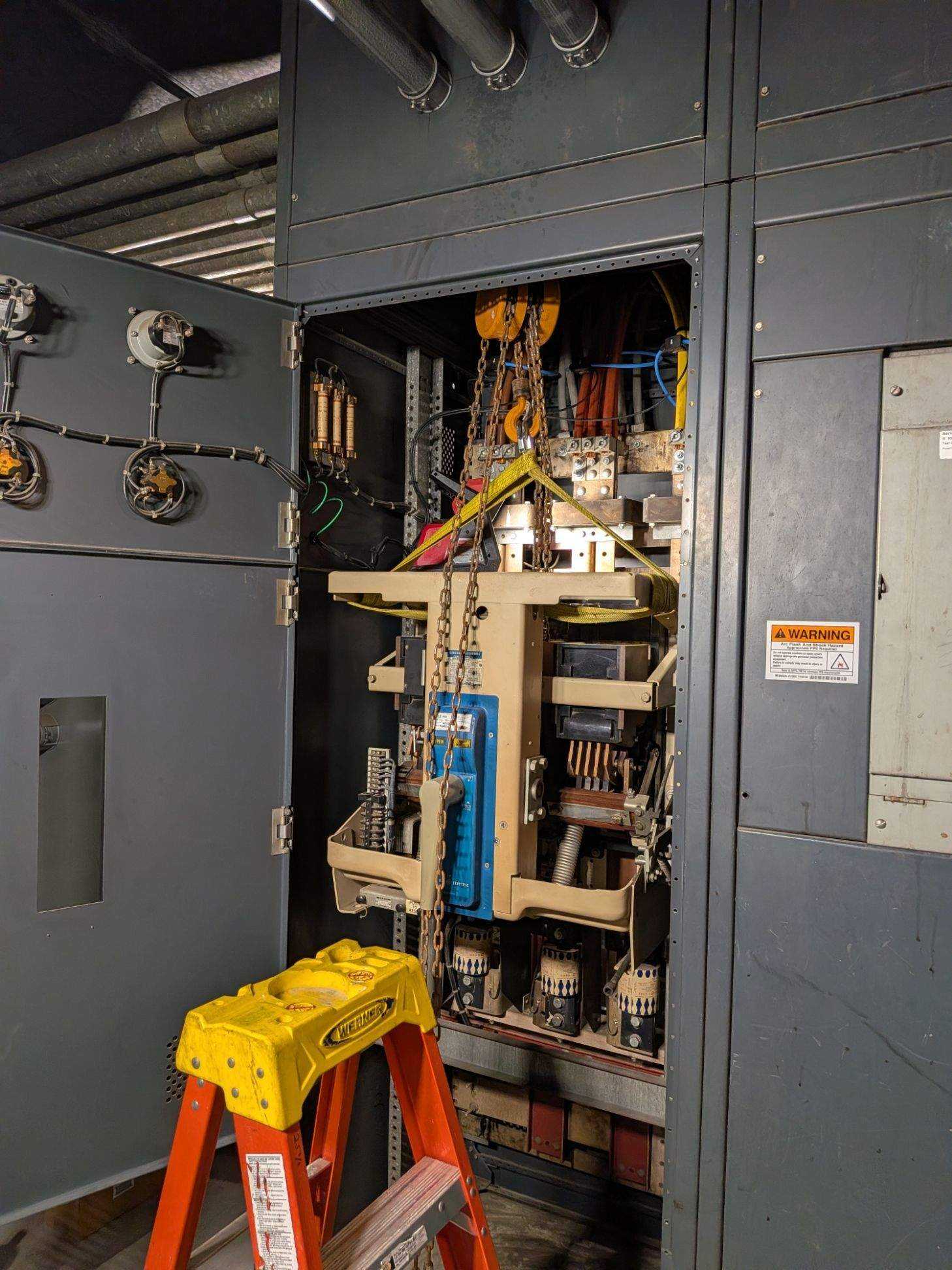 Old breaker being extracted with chain hoist